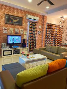 卢穆特Sitiawan Paradise Teluk Batik Karaoke Snooker BBQ 15Pax的带沙发和电视的客厅