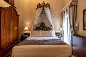 切雷托圭迪Villa Petriolo的一间卧室配有一张特大号床和天蓬