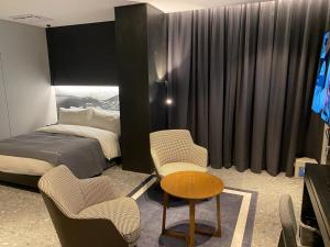 安城市Anseong City Hotel的卧室配有一张床和一张桌子及椅子
