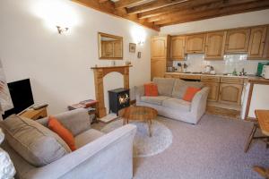 贝图瑟科伊德Royal Oak Farm Cottage的客厅设有两张沙发和一个壁炉