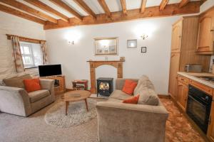 贝图瑟科伊德Royal Oak Farm Cottage的带沙发和壁炉的客厅