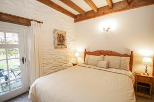 贝图瑟科伊德Royal Oak Farm Cottage的卧室配有白色的床和窗户。