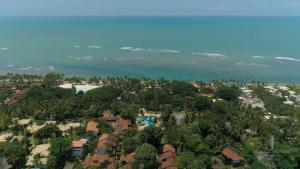 阿拉亚尔达茹达Cores do Arraial Residence Hotel的享有度假小镇的空中美景和海滩