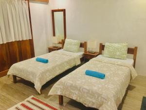 邦劳帕西路拿旅馆的客房内的两张床和蓝色枕头