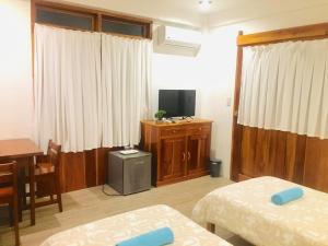 邦劳帕西路拿旅馆的客房设有两张床、一张桌子和一台电视。