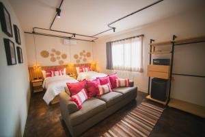 瓦哈卡市Casa Rosamate的一间卧室配有两张床和一张带粉红色枕头的沙发。