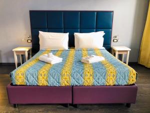 佛罗伦萨乔意亚酒店的一间卧室配有一张床,上面有两条毛巾