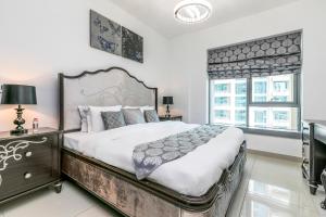 迪拜1BR Boulevard View 29 Blvd T2 Downtown的一间卧室设有一张大床和两个窗户。