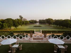 斋浦尔Rajmahal Palace RAAS的享有公园美景,配有桌子和遮阳伞