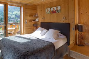 大博尔南Chalet-Hotel et Spa Le Delta的一间卧室设有一张床和一个大窗户