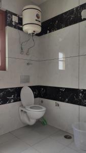 ShamshiMathan View Homestay的浴室配有卫生间和墙上的灯。