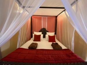 桑给巴尔Jafferji House的一间卧室配有红色和白色窗帘的床