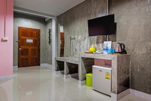 甲米镇The Guest Hotel Krabi的一间设有柜台的房间和墙上的电视