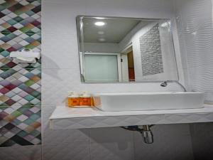 甲米镇The Guest Hotel Krabi的浴室设有白色水槽和镜子