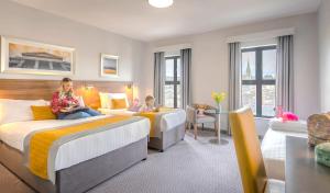 伦敦德里德里玛尔顿酒店的两名女孩坐在酒店房间的床边