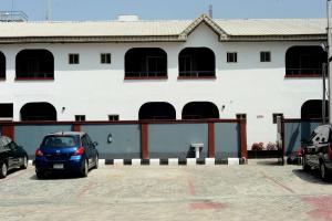 拉各斯Mariners Suites Lagos的停车场内有停车位的白色建筑