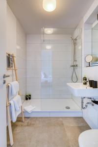 嘉兴贝慕尼黑limehome Garching bei München的带淋浴和盥洗盆的白色浴室