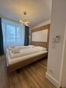 萨尔茨堡Villa Flöckner Bed & Breakfast的一间卧室配有一张大床和一个吊灯。