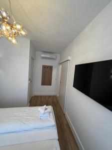 萨尔茨堡Villa Flöckner Bed & Breakfast的卧室配有壁挂式大屏幕平面电视。