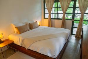 涛岛Big Tree Boutique Hotel的一间卧室配有一张带白色床单和窗户的床。