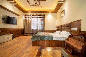 ShamshiMathan View Homestay的一间卧室配有一张床和一台电视