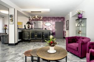 卡朗泰克The Originals Boutique, Hôtel La Baie de Morlaix的客厅配有紫色沙发和桌子