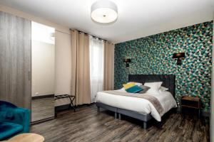 卡朗泰克The Originals Boutique, Hôtel La Baie de Morlaix的一间卧室设有一张床和蓝色绿色的墙壁