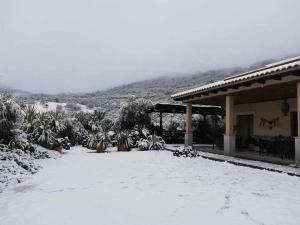 Herrera del DuqueCasa rural la huerta de los nogales的一座房子旁边的雪地里