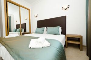 拉戈斯Fairviews Villa on Boavista Golf Resort的一间卧室配有两张蓝色和白色的床