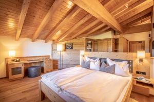 Hellengerst哈努赛尔霍夫酒店的一间卧室设有一张大床和木制天花板。