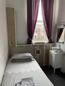 泰恩河畔纽卡斯尔宾利酒店的一间卧室配有床、水槽和窗户