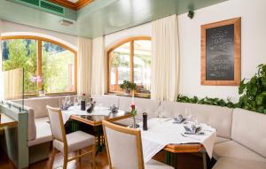 贝旺楚格峰美景酒店的餐厅设有白色的桌椅和窗户。