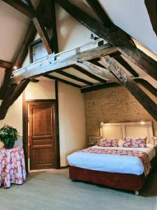 内尔河畔欧比尼La Chaumière的阁楼上的卧室配有一张大床