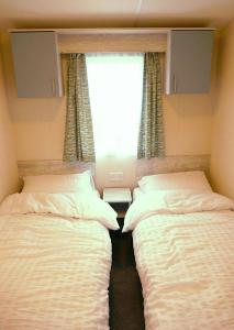 米勒姆Plot 8 Lakeside Cabin, Wyldecrest, Millom的小型客房 - 带2张床和窗户