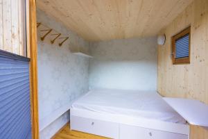 ScheibbsCHECKIN THE BOX Schloss Neubruck的一间小卧室,配有一张床和木制天花板