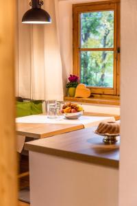基茨比厄尔Ferienwohnung Neuhaus的厨房配有带一碗水果的桌子和窗户