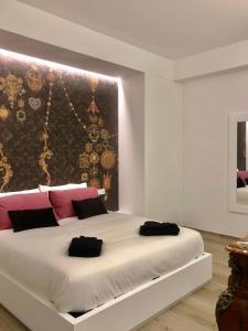 那不勒斯Gonzaga Guest House的卧室配有带粉色和黑色枕头的大型白色床。