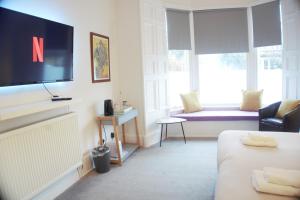 艾尔Barns Serviced Accommodation的客房设有床、电视和沙发。