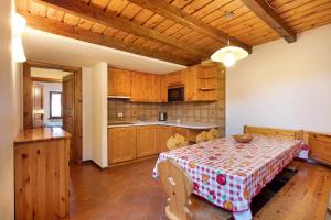 利维尼奥Chalet Meridiana Appartamento 9的一间带桌子的厨房和一间带木制橱柜的厨房