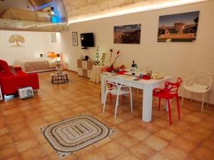 马泰拉Il Risveglio nei Sassi的客厅配有白色桌子和红色椅子
