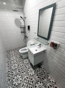 屏东县麟家民宿的一间带卫生间、水槽和镜子的浴室