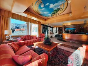 布吕松HG Hotel Italia的一个带红色沙发和舞台的大客厅