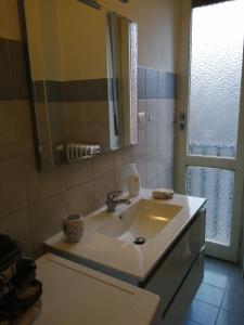 阿斯蒂Casa arcobaleno的一间带水槽和镜子的浴室以及窗户。