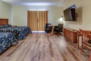罗贝瓦勒罗伯瓦尔汽车旅馆的酒店客房设有两张床、一张桌子和一台电视。