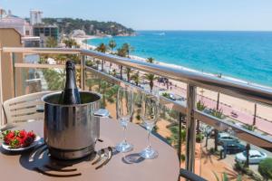 罗列特海岸马索尔酒店的阳台上的桌子上配有一瓶香槟和玻璃杯