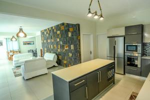 格兰贝伊New Villa Geranium的厨房以及带炉灶和冰箱的客厅。