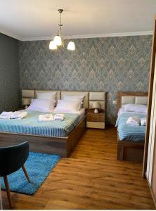 卡兹贝吉GOLDEN STAR KAZBEGI的一间卧室配有两张床和吊灯。