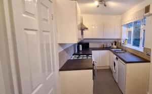 Killingbeck✪ Spacious Luxury 2-bed w/ parking & garden的厨房配有白色橱柜和水槽