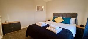 Killingbeck✪ Spacious Luxury 2-bed w/ parking & garden的一间卧室配有带毛巾的床