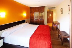 埃特克萨拉尔文塔德埃萨拉尔酒店的一间卧室配有一张带红色毯子的大床